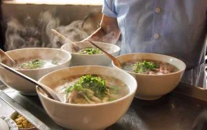4 steaming bowls of Vietnamese Pho Bo, a popular street food in Hanoi