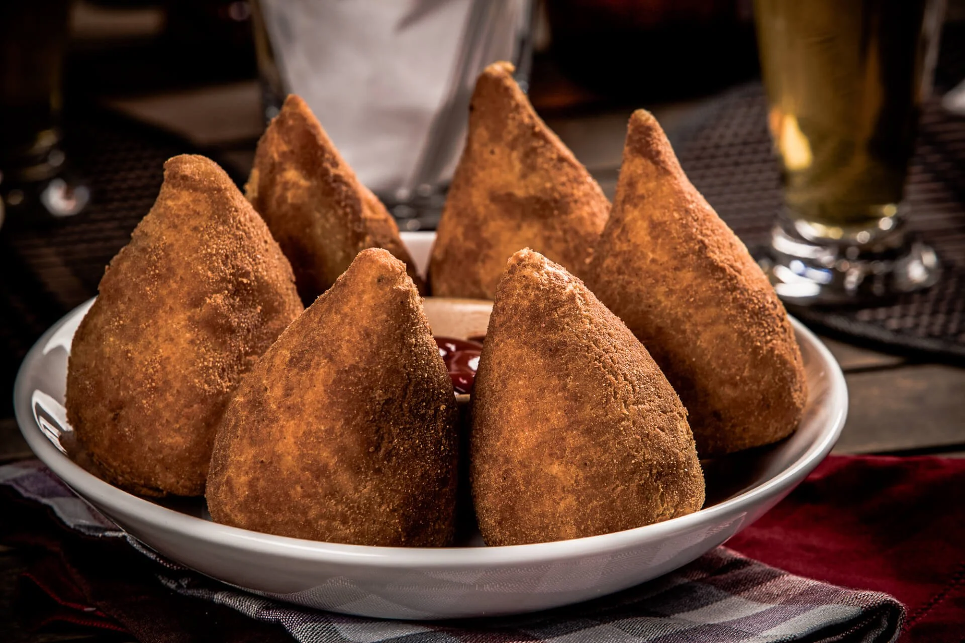 Popular Brazilian foods: Coxinha, a Brazilian snack, with a bar in the background.