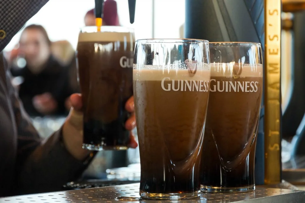 DUBLIN, IRELAND - FEB 15, 2014: Pints of beer are served at The Guinness Brewery on Feb 15, 2014. The brewery where 2.5 million pints of stout are brewed daily was founded by Arthur Guinness in 1759.