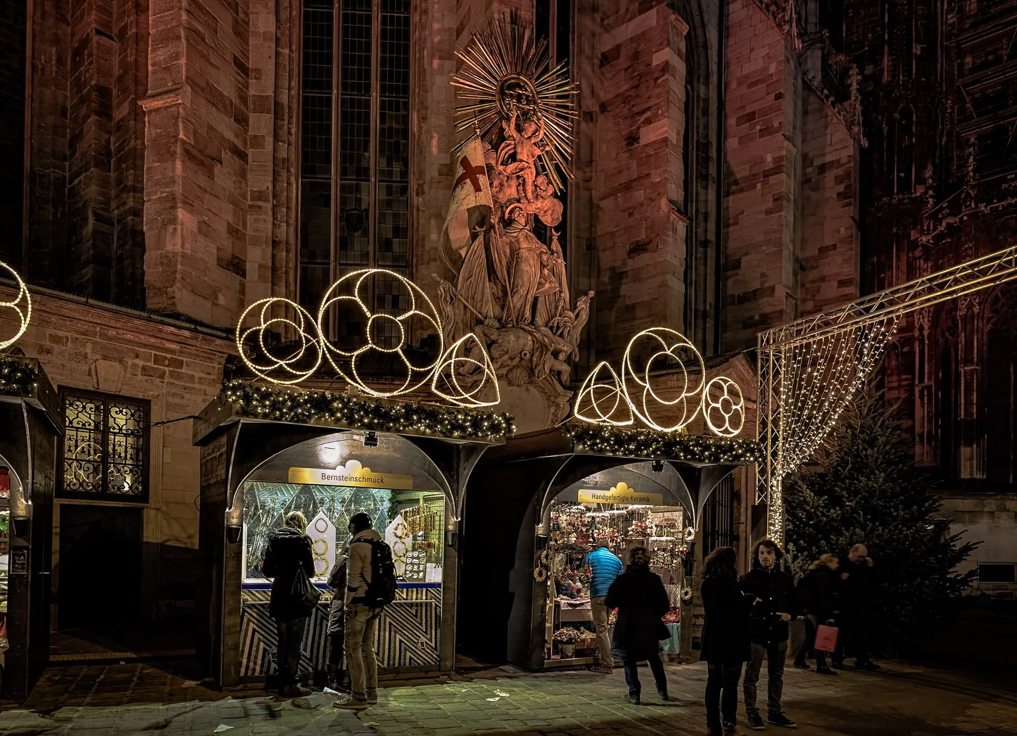 Stephansplatz Christmas market around the St. Stephen's Cathedral in Vienna, Austria. Two market stall under the 18th century Baroque statue of St. Francis trampling on a beaten Turk.