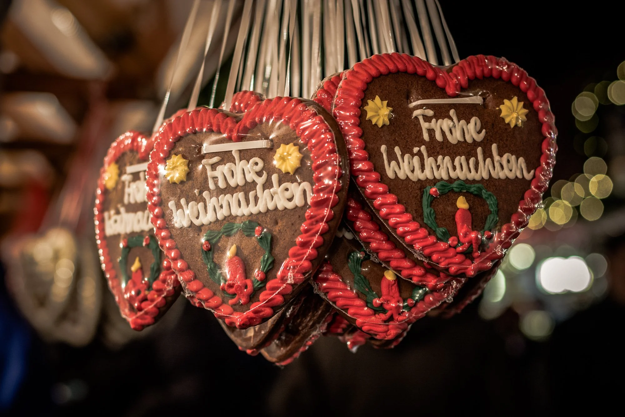 Merry Christmas written in German on gingerbread hearts at a Christmas market close up