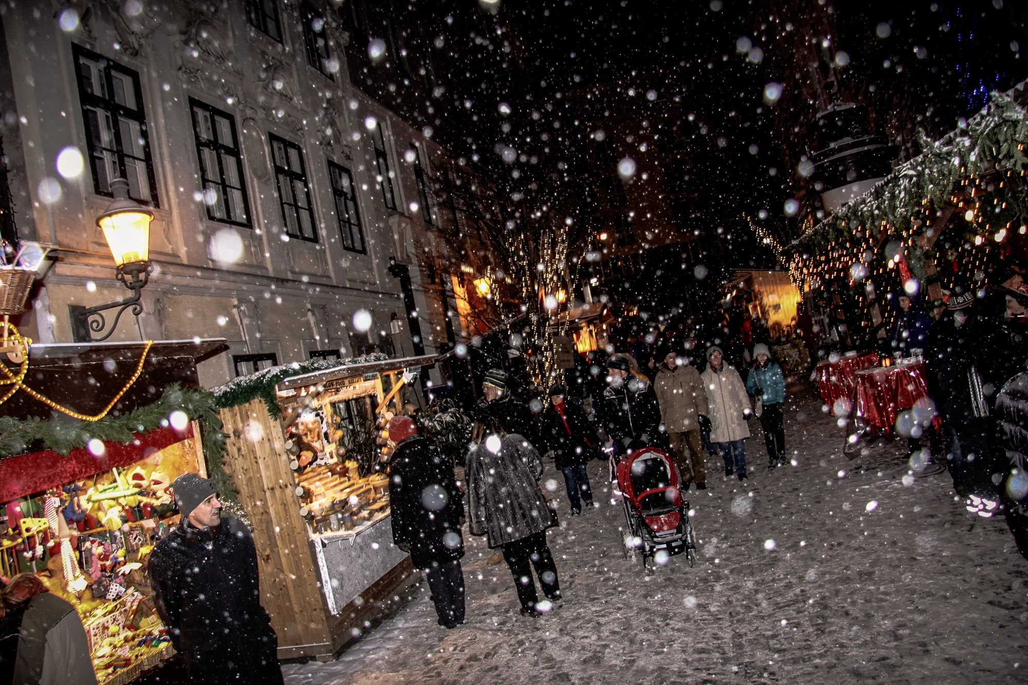 Snow falling at night at the Spittelberg Christmas Market in Vienna
