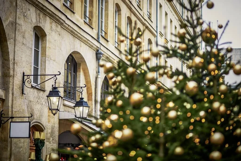 Christmas trees decorated with golden balls on a street of Paris. Seasonal winter holidays concept