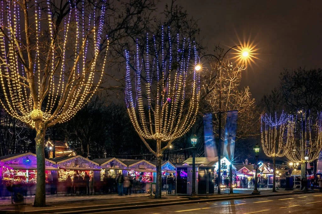 Festively decorated and illuminated Champs Elysees and Christmas market at night, France