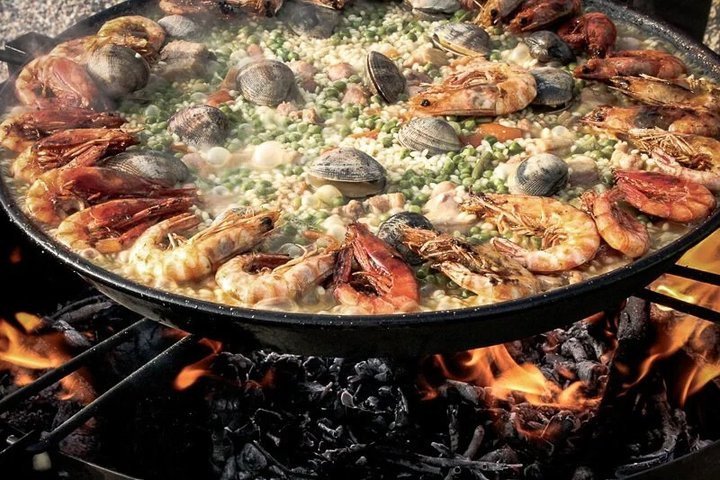 Spanish paella cooking over an open fire