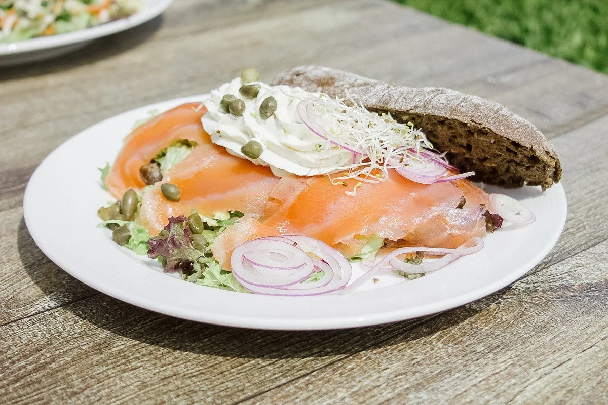 salad of salmon, red onion, cream, and capers on a plate with brown bread